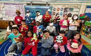 Students taking picture on the rug with stuffed animals