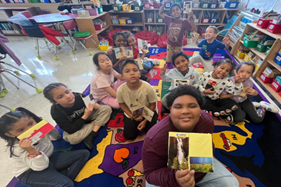 Students sitting on a rug.