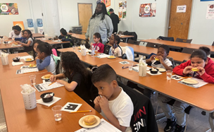 kids sitting on long school benches eating